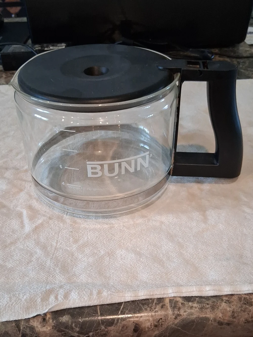 Bunn 10-cup replacement glass carafe featuring a black lid and handle.